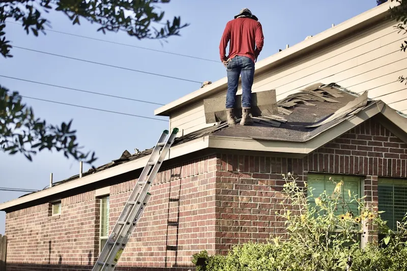 Professional roofer working on a residential roof in Queen Acres